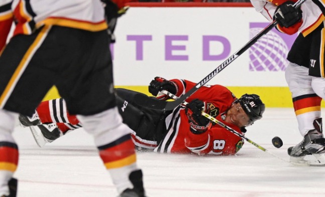 Marian Hossa tries to control the puck after falling to the ice Monday night.